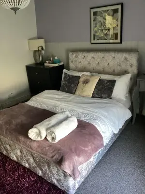 a bedroom with a bed with two towels on it at The lavender house 513 halliwell rd bolton bl18db in Bolton