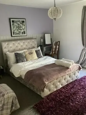 a bedroom with a bed and a desk with a chair at The lavender house 513 halliwell rd bolton bl18db in Bolton