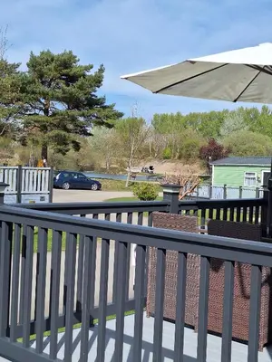 a balcony with an umbrella and a car on a street at Inside No.2 Retreat in Carnforth