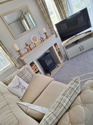 a living room with a couch and a tv and a fireplace at Inside No.2 Retreat in Carnforth