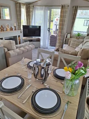 a dining room table with plates and flowers on it at Inside No.2 Retreat in Carnforth