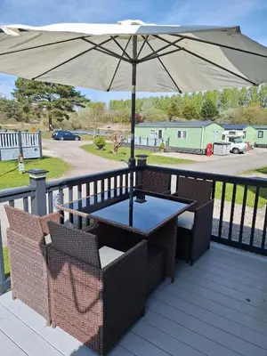 a table and chairs under an umbrella on a deck at Inside No.2 Retreat in Carnforth
