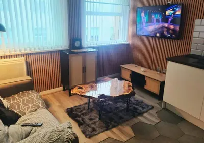 a living room with a couch and a tv at The Halifax Suites Near Albert Dock sleeps 3 in Liverpool