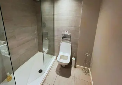 a bathroom with a toilet and a glass shower at The Halifax Suites Near Albert Dock sleeps 3 in Liverpool