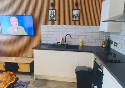 a kitchen with a sink and a tv on the wall at The Halifax Suites Near Albert Dock sleeps 3 in Liverpool