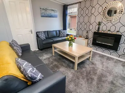 a living room with a couch and a table at Park View Lodge, Arnside 7 in Carnforth