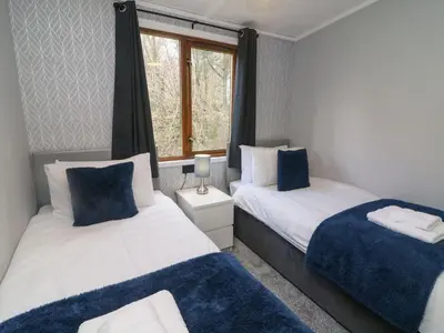 a bedroom with two beds and a window at Park View Lodge, Arnside 7 in Carnforth