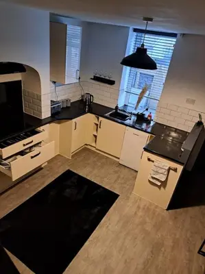 a large kitchen with black counter tops in a room at Cosy 19th century town-house in Clitheroe