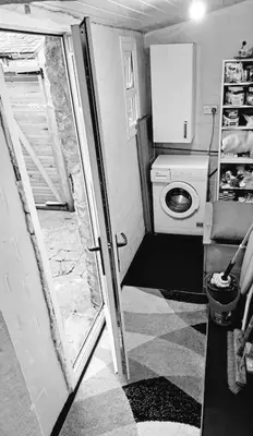 a small bathroom with a washing machine and a door at Cosy 19th century town-house in Clitheroe