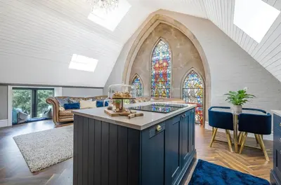 a kitchen with a blue island in a living room at Chapel Apartment in Liverpool