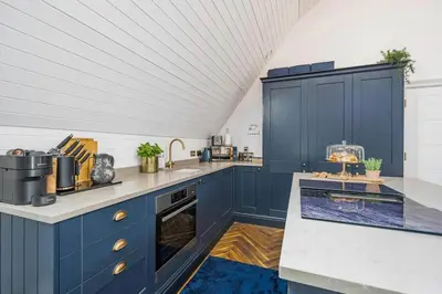 a kitchen with blue cabinets and a white ceiling at Chapel Apartment in Liverpool