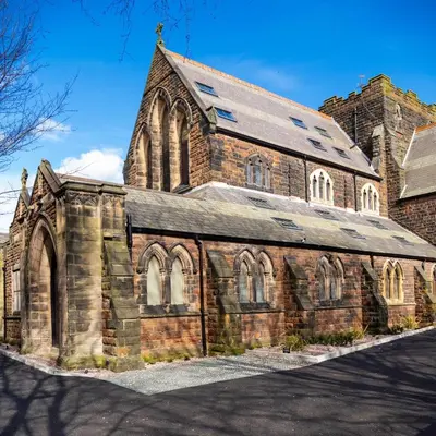 an old brick church with a roof on a street at Chapel Apartment in Liverpool
