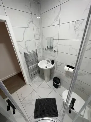 a white bathroom with a sink and a toilet at Galway Suite in Preston