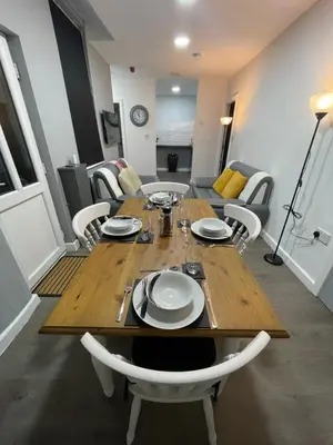 a wooden table and chairs in a living room at Galway Suite in Preston