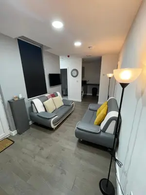 a living room with two couches and a lamp at Galway Suite in Preston