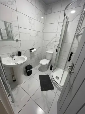 a bathroom with a toilet and a shower and a sink at Galway Suite in Preston