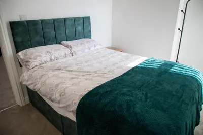 a bed with a green headboard and a blanket on it at Balmoral Stays 3 - First Floor in Blackpool