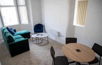 a living room with a couch and a table and chairs at Balmoral Stays 3 - First Floor in Blackpool