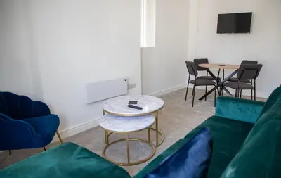 a living room with a couch and a table and chairs at Balmoral Stays 3 - First Floor in Blackpool