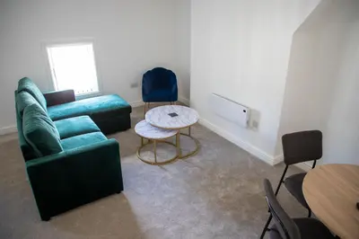 a living room with a couch and a table and chairs at Balmoral Stays 5 - Second Floor in Blackpool