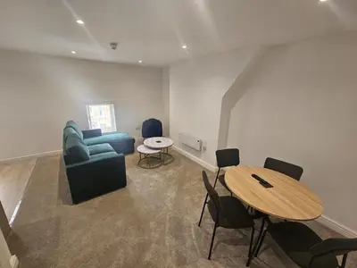 a living room with a blue couch and a table at Balmoral Stays 5 - Second Floor in Blackpool