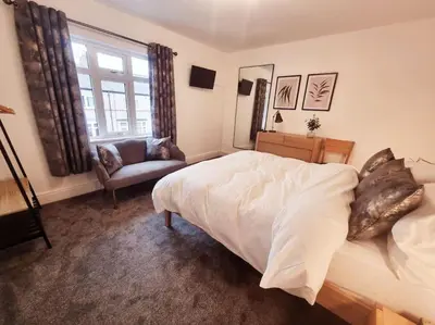 a bedroom with a bed and a couch and a window at Central Lancaster City Centre Terraced Gem in Lancaster