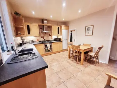 a kitchen with a table and a dining room at Central Lancaster City Centre Terraced Gem in Lancaster