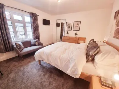 a bedroom with a bed and a couch and a window at Central Lancaster City Centre Terraced Gem in Lancaster