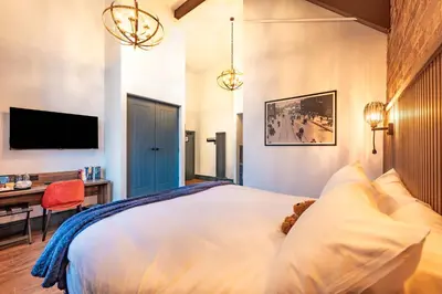 a bedroom with a large white bed and a desk at The Old Lyric Hall - A St David Aparthotel in Barrow in Furness
