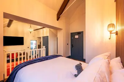 a bedroom with a bed with a cat sitting on it at The Old Lyric Hall - A St David Aparthotel in Barrow in Furness