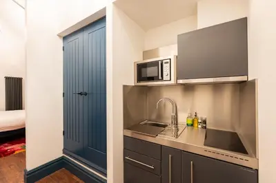 a kitchen with a sink and a microwave at The Old Lyric Hall - A St David Aparthotel in Barrow in Furness