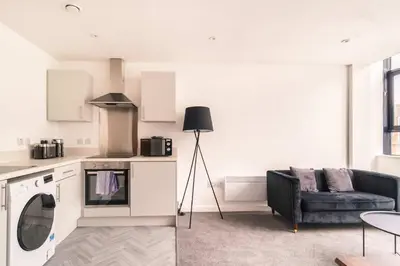 a kitchen and a living room with a couch at Central Preston Lovely 1 Bedroom Apartment in Preston