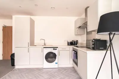 a kitchen with a washing machine and a lamp at Central Preston Lovely 1 Bedroom Apartment in Preston