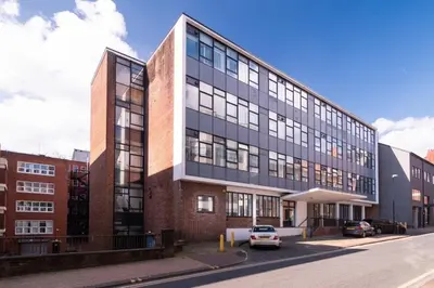 a large building with a car parked in front of it at Central Preston Lovely 1 Bedroom Apartment in Preston