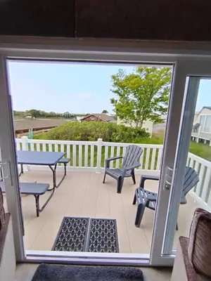 a screened porch with two chairs and a table and benches at Sandpiper Port Haverigg Marina in Millom