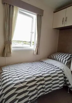 a bedroom with a zebra print bed in front of a window at Sandpiper Port Haverigg Marina in Millom