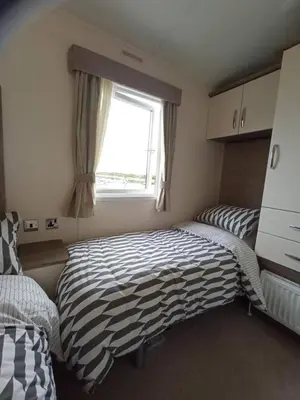 a bedroom with two twin beds and a window at Sandpiper Port Haverigg Marina in Millom