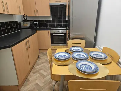 a kitchen with a table with blue and white plates on it at Liverpool Haven, Stylish and Spacious 3-Bedroom Apartment with City Access in Liverpool
