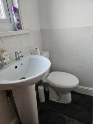 a bathroom with a white sink and a toilet at Liverpool Haven, Stylish and Spacious 3-Bedroom Apartment with City Access in Liverpool