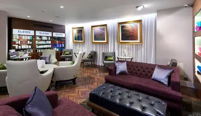 a waiting room with couches and chairs and a library at DoubleTree by Hilton Hotel & Spa Liverpool in Liverpool