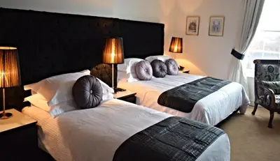 a hotel room with two beds and two lamps at The Georgian Town House Hotel in Liverpool