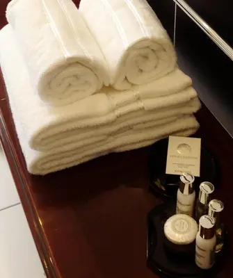 a pile of towels on a table in a bathroom at The Georgian Town House Hotel in Liverpool