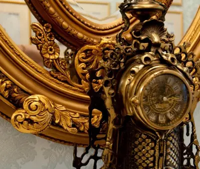 a gold clock in front of a mirror at The Georgian Town House Hotel in Liverpool