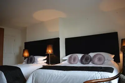 a bedroom with two beds with white sheets and purple pillows at The Georgian Town House Hotel in Liverpool