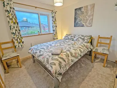 a bedroom with a bed and two chairs and a window at Bright Double Room l Smart TV l 5 Minute Walk from Train Station in Egerton