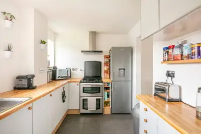 a kitchen with a stainless steel refrigerator and white cabinets at Bright Double Room l Smart TV l 5 Minute Walk from Train Station in Egerton