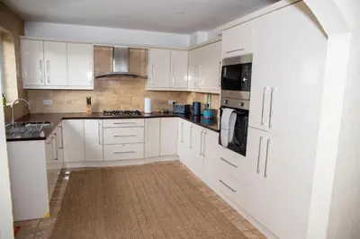 a white kitchen with white cabinets and appliances at Highcross Corner in Poulton le Fylde