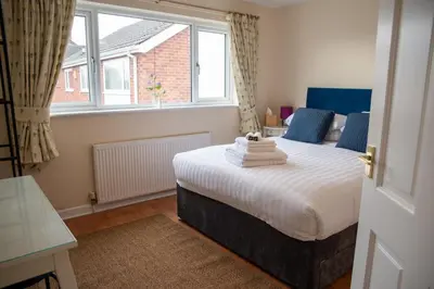 a bedroom with a large bed in front of a window at Highcross Corner in Poulton le Fylde