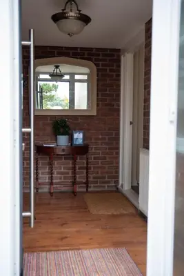 a room with a brick wall and a table with a window at Highcross Corner in Poulton le Fylde