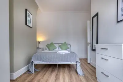 a bedroom with a bed with green pillows on it at Vibrant Artist Hideaway by Centre Parking in Liverpool